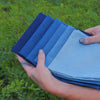 Range of indigo dyed fabric samples from pale wash to deep blue